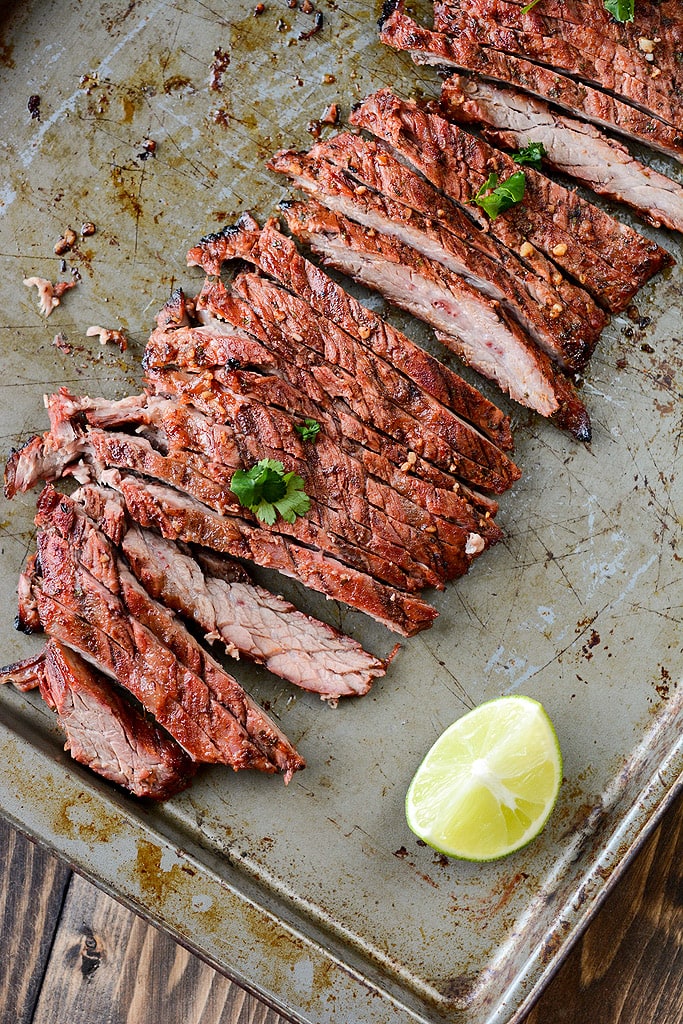 Grilled Carne Asada on a sheet pan with a lime