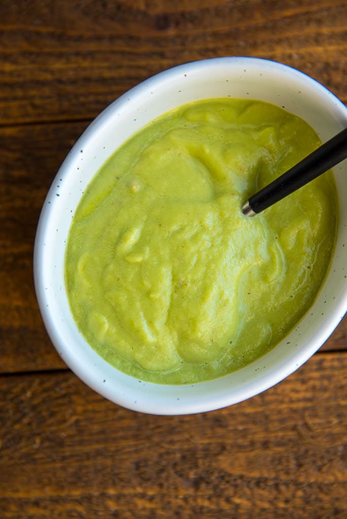 Vegan Avocado Sauce in white oval bowl for Crispy Chickpea Tostadas