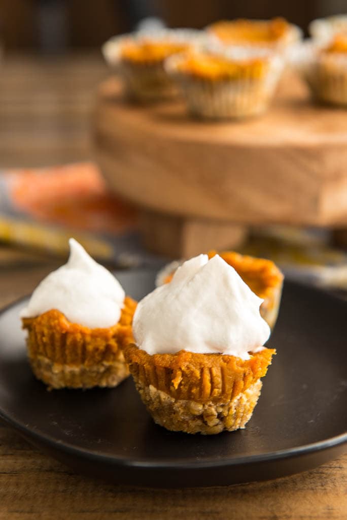 Mini Pumpkin Pies on black plate with extra pies in background