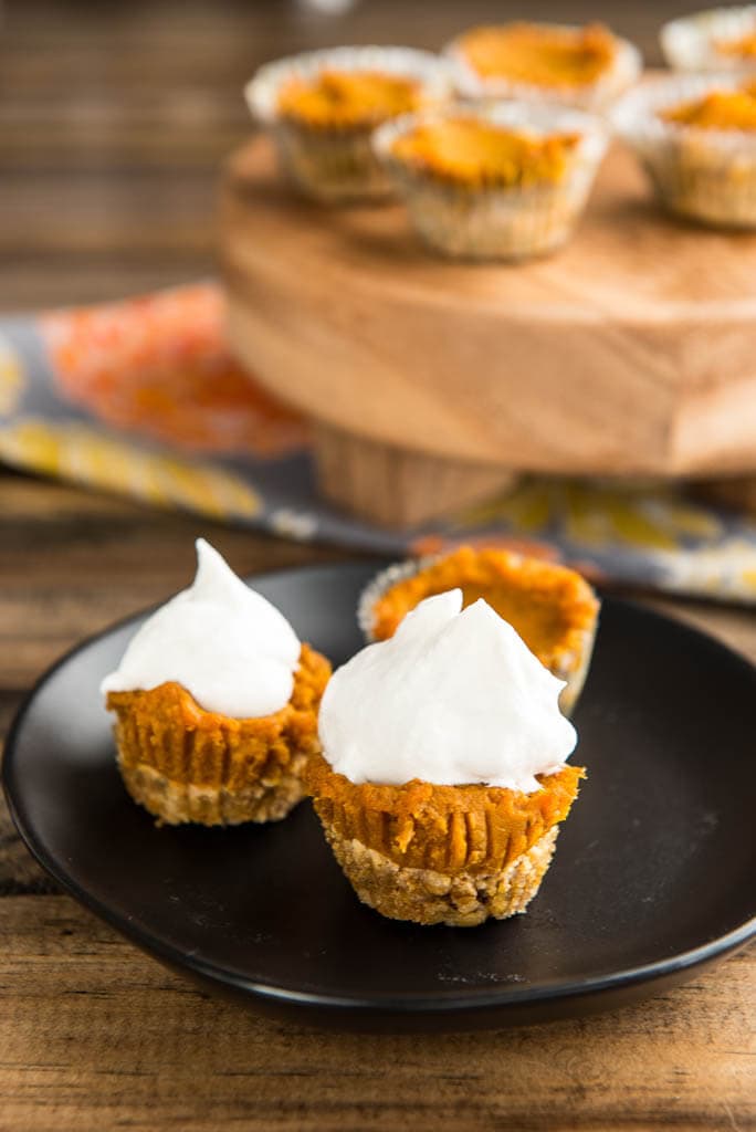 Mini Pumpkin Pies on black plate with extra pies in background