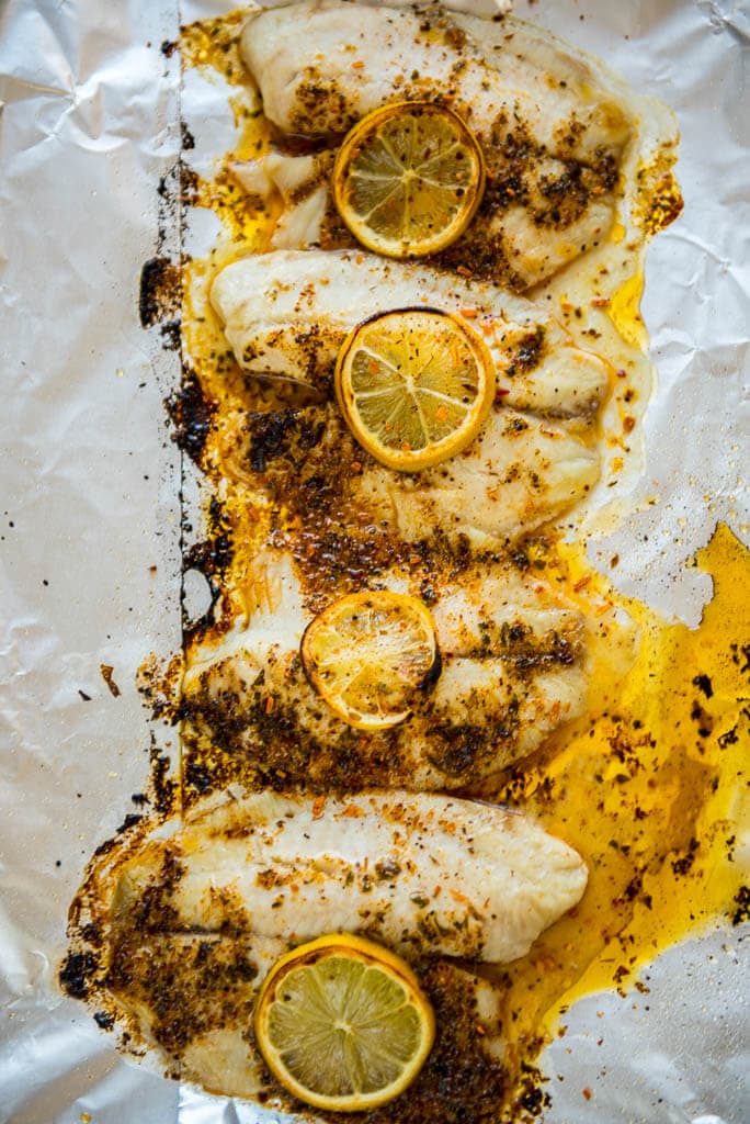 Baked Lemon Butter Tilapia on foil lined baking sheet lightly browned and ready to serve