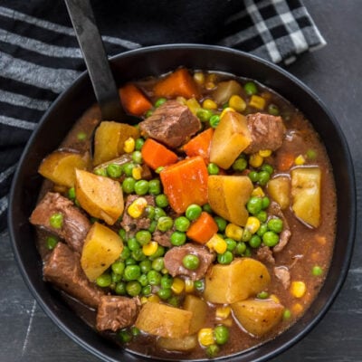Slow Cooker Beef Stew in Black Bowl from overhead on gray table with black napkin