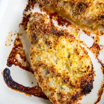 Parmesan Oven Baked Pork Chops in red and white casserole dish