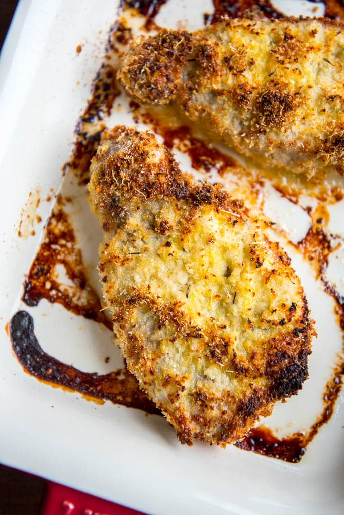 Parmesan Oven Baked Pork Chops in red and white casserole dish