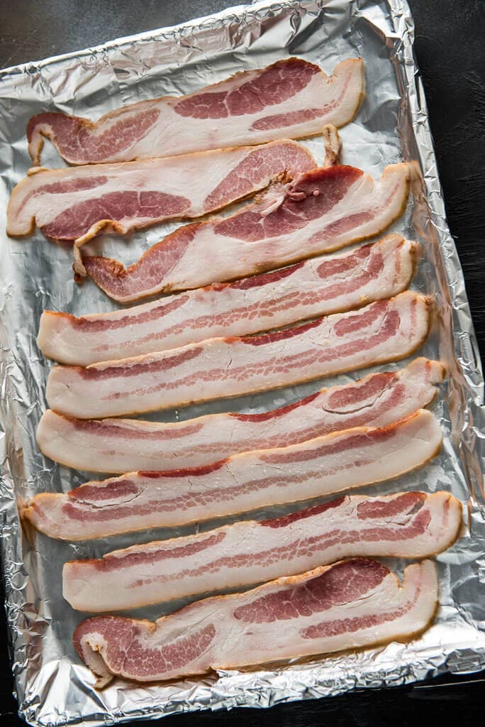 bacon on a baking sheet to learn how to make bacon in the oven