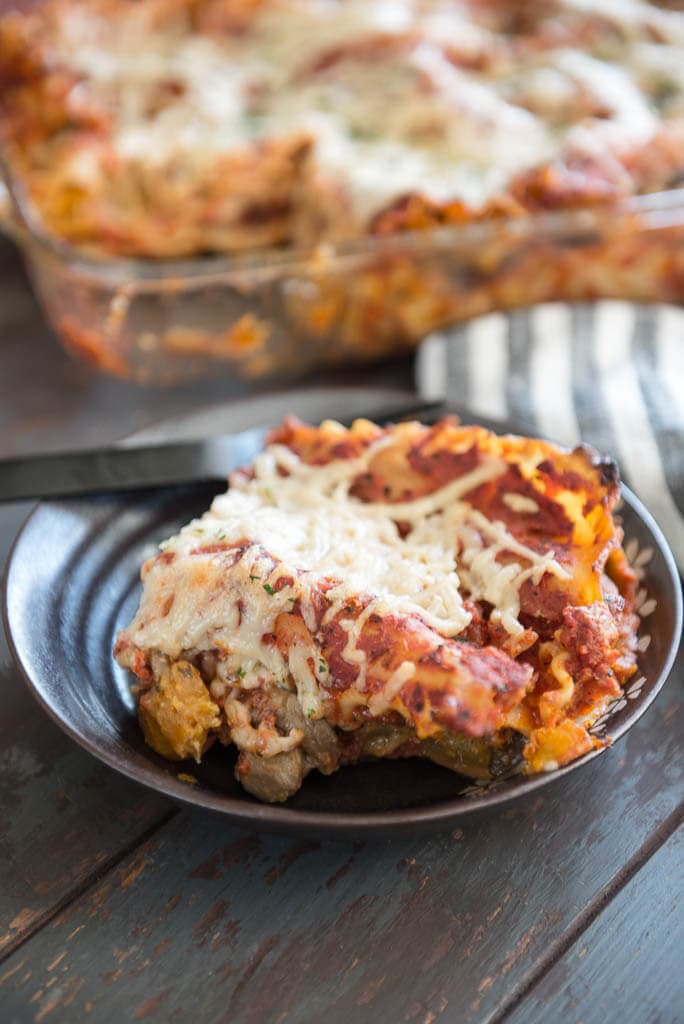 one piece of vegan lasagna dished onto a brown plate with black fork ready to eat