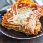 Vegan Lasagna on a brown plate with a gray striped napkin