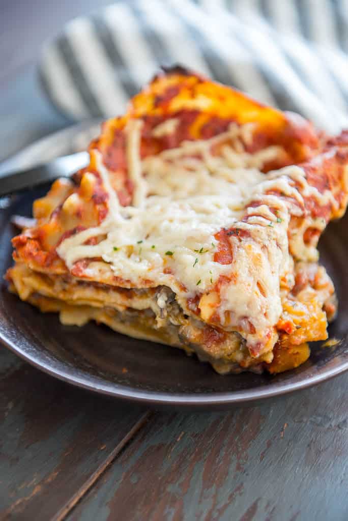 Vegan Lasagna on a brown plate with a gray striped napkin