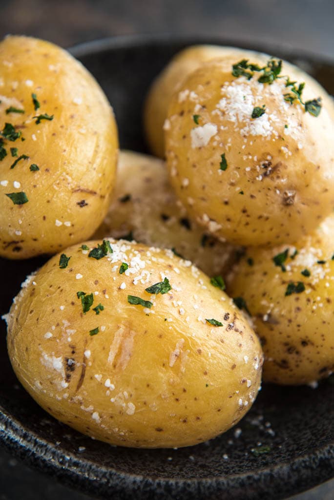 baked potatoes with salt and parsley in a large bowl