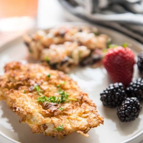 Air fryer potato chip chicken breast on white plate with pasta salad and fruit