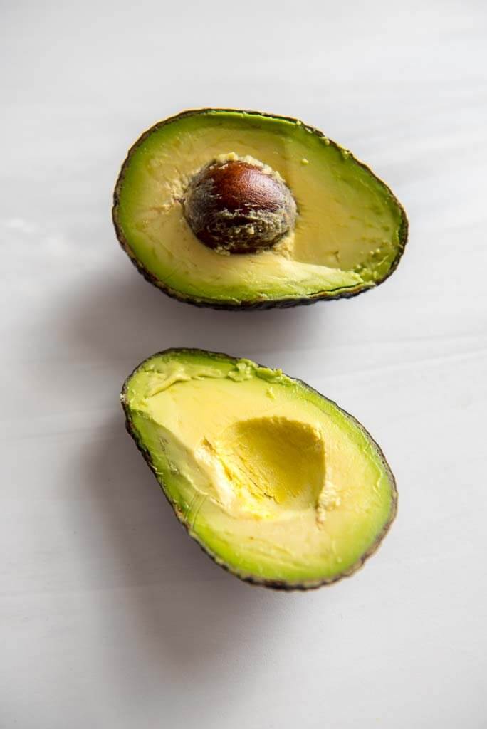 avocado cut in half on white background