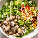 Grilled Chicken Taco Salad in white bowl with ranch dressing drizzle
