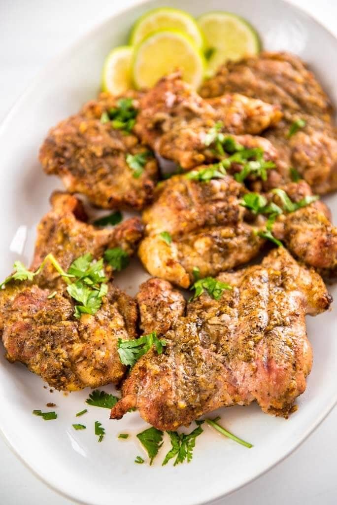 grilled chicken thighs on white platter