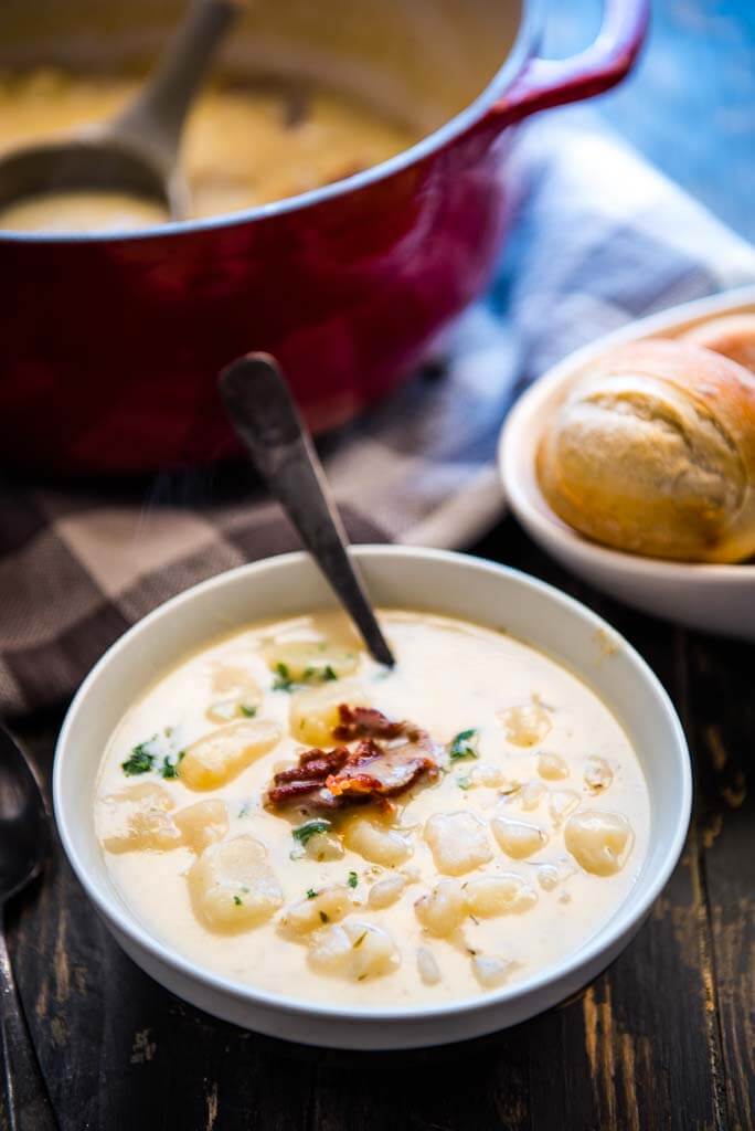creamy potato soup topped with bacon crumbles with a side of rolls