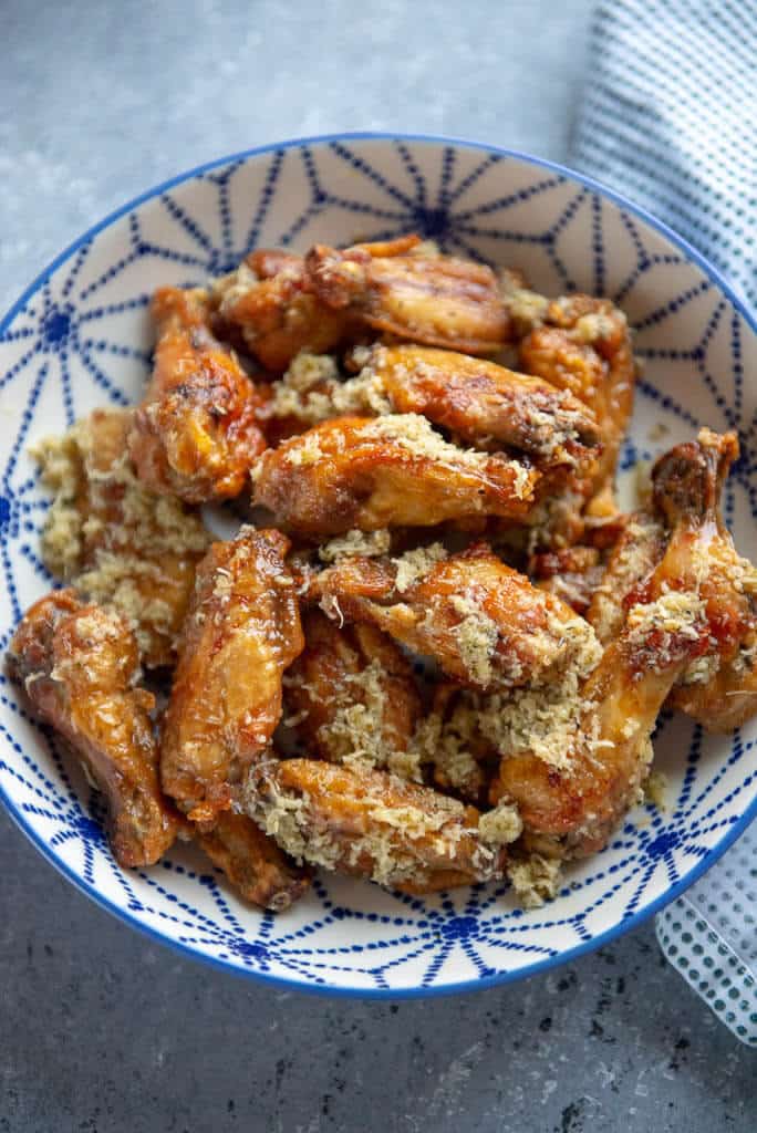 chicken wings with garlic and parmesan in a blue and white bowl