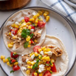 chicken tacos with corn salsa on white plate