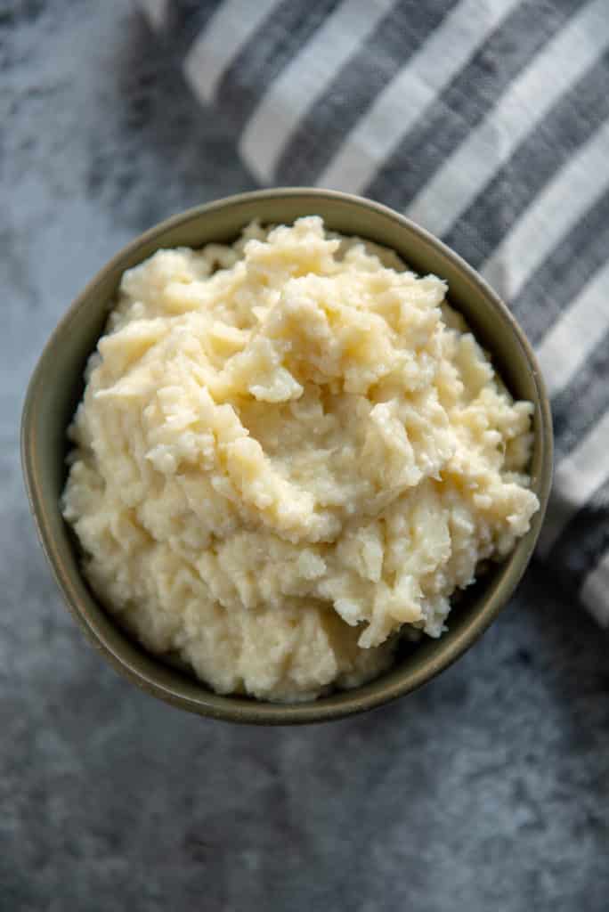 mashed cauliflower in a gray bowl with a striped napkin