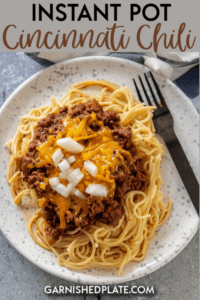 It may not really be chili, but it's delicious none the less! Enjoy this easy Instant Pot Cincinnati Chili over steaming spaghetti noodles and topped with plenty of melty cheese. Onions optional! #instantpot #cincinnatichili #pasta