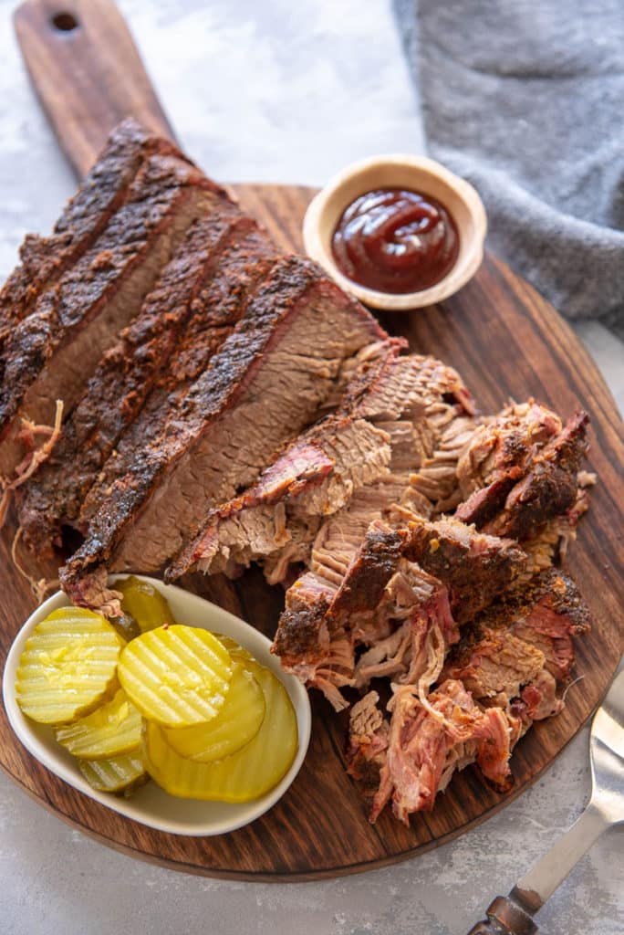 sliced brisket on round wood board