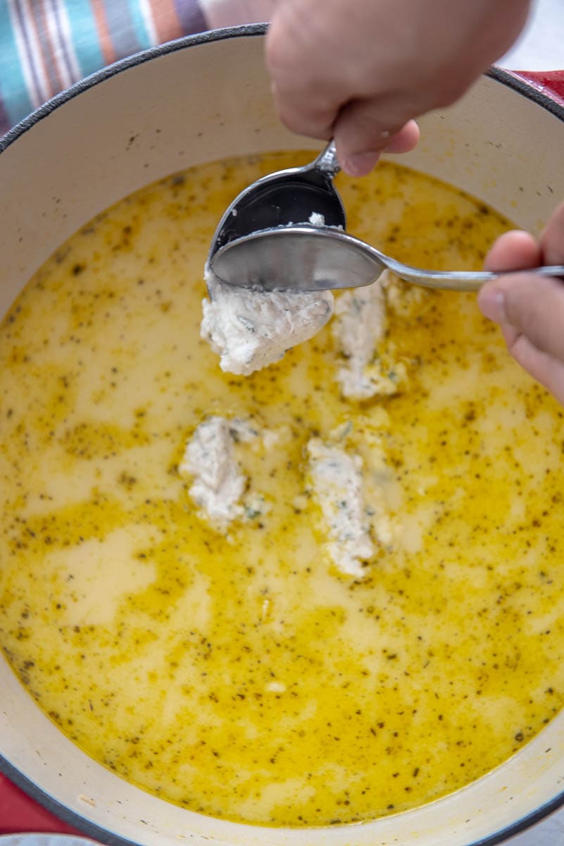 Adding dumpling batter to chicken broth in dutch oven
