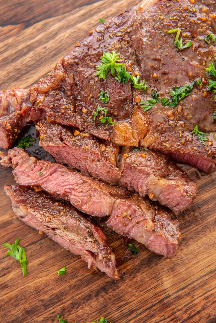 sliced ribeye steak on wood cutting board