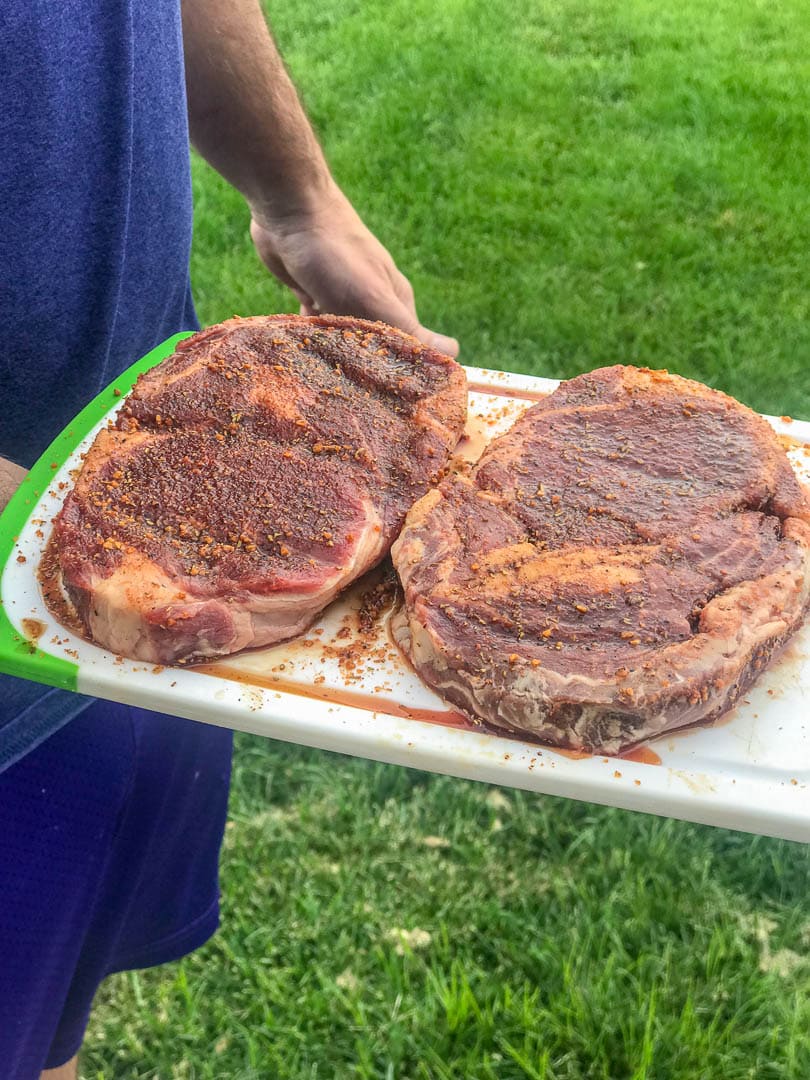 2 ribeye steaks on board ready for grill