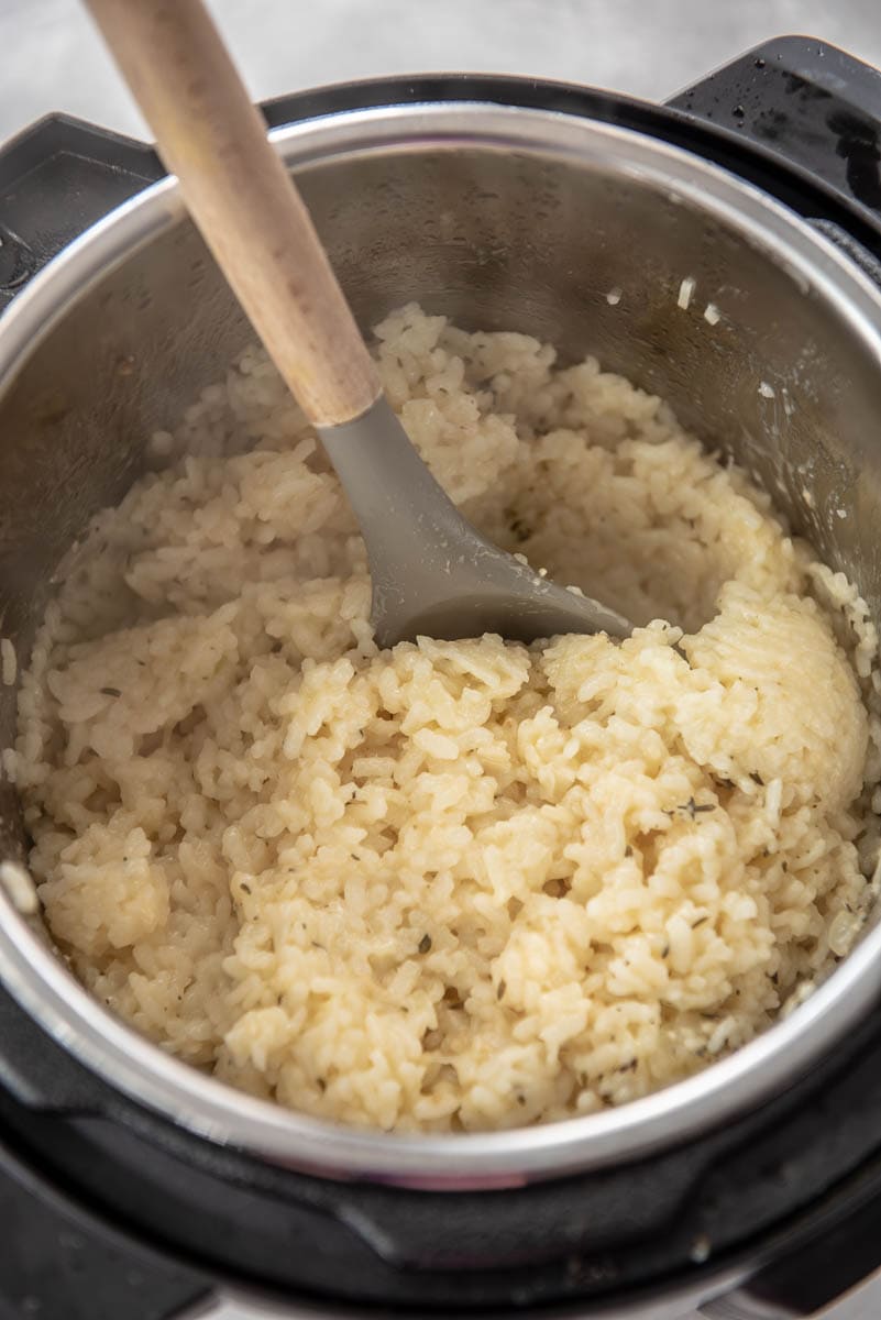 instant pot with spoon filled with risotto