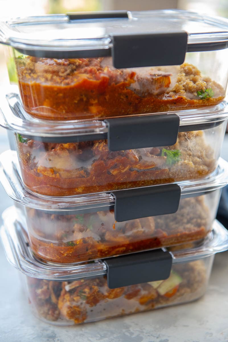 clear food containers stacked and filled with Moroccan chicken and quinoa