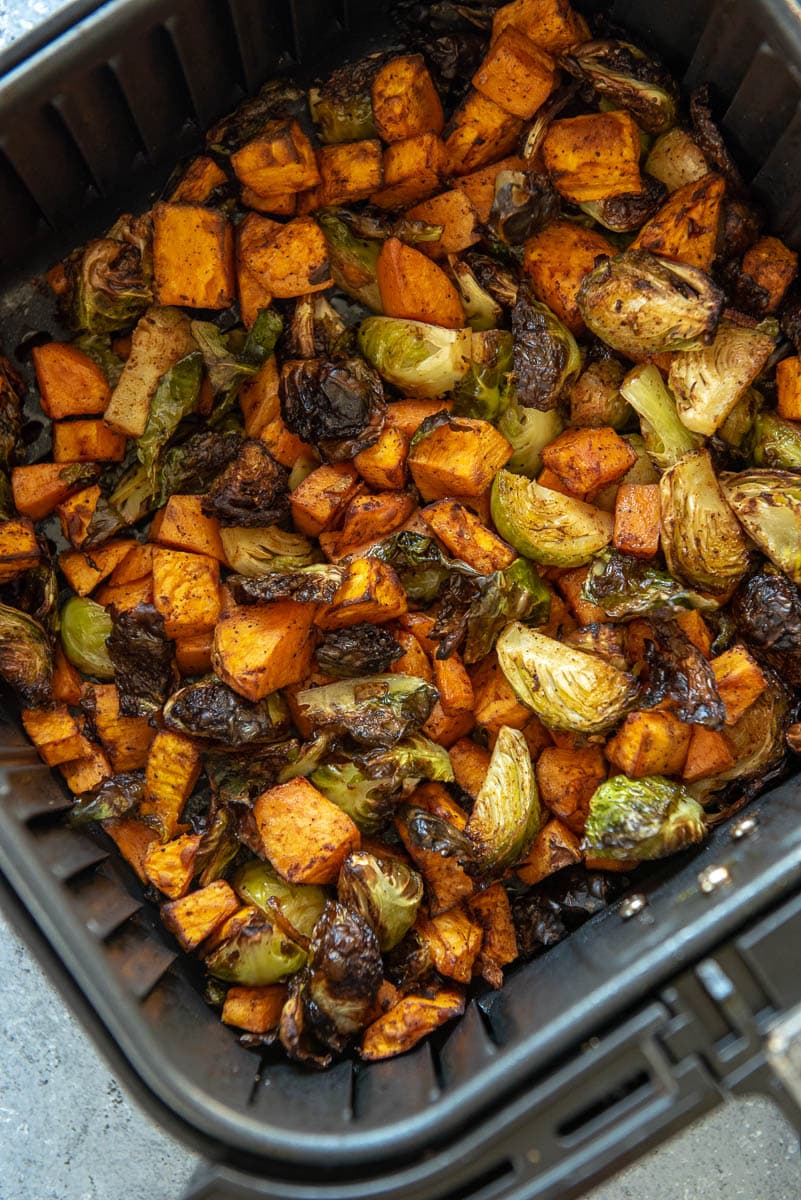 sweet potatoes and Brussels sprouts in air fryer basket