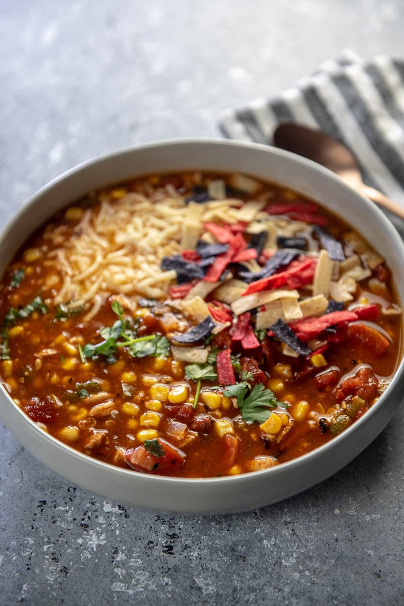 bowl of turkey tortilla soup with cheese and tortilla strips