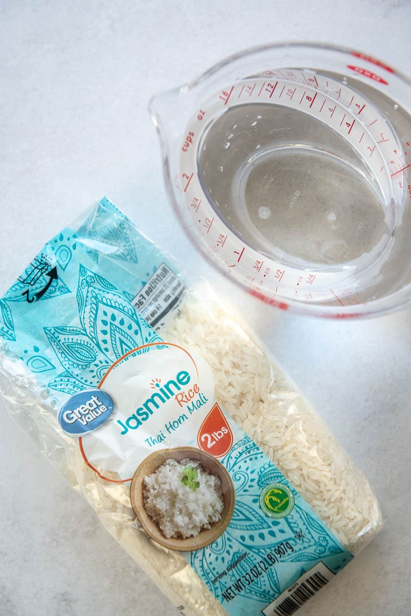 bag of jasmine rice and measuring cup with water