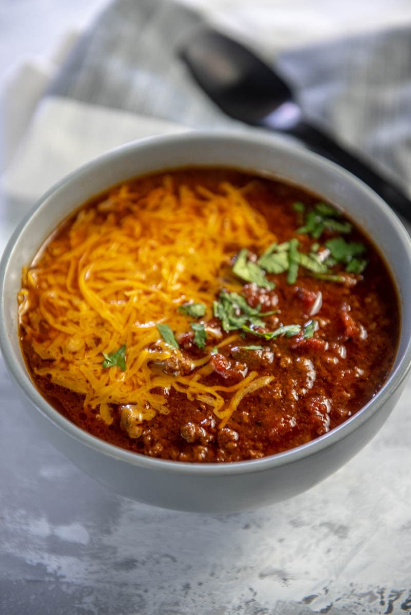 beef chili topped with cheese in gray bowl