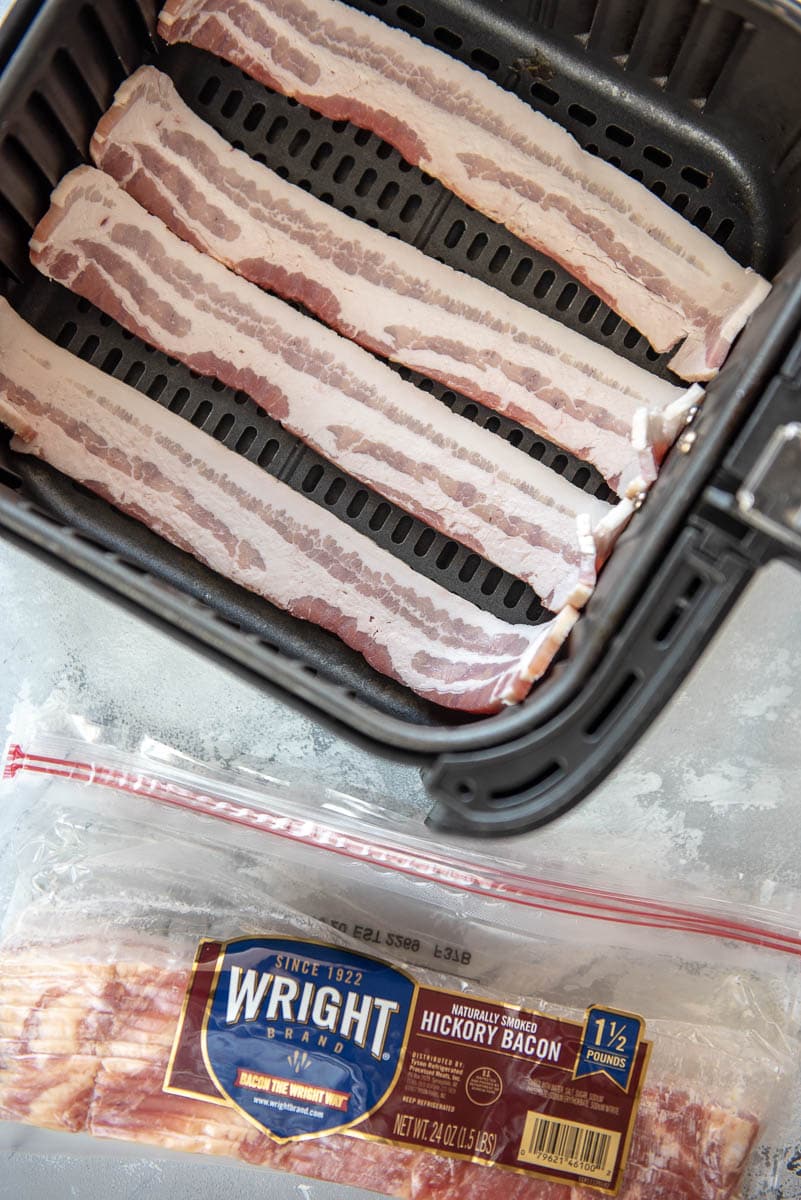 air fryer basket with raw bacon next to bacon package