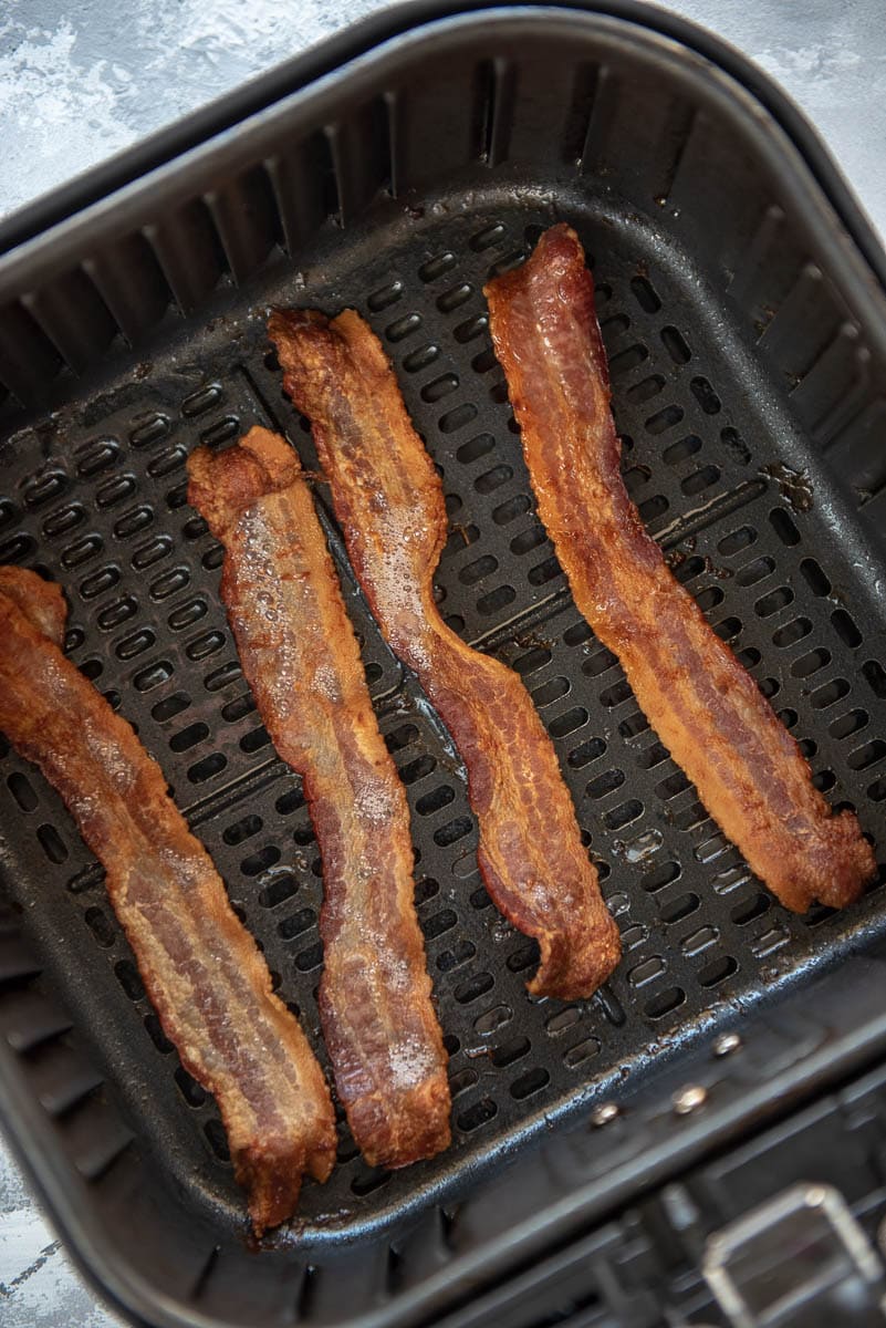 4 strips of cooked bacon in air fryer basket