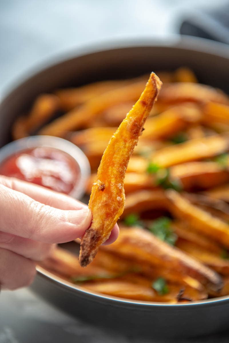 holding a single sweet potato fry