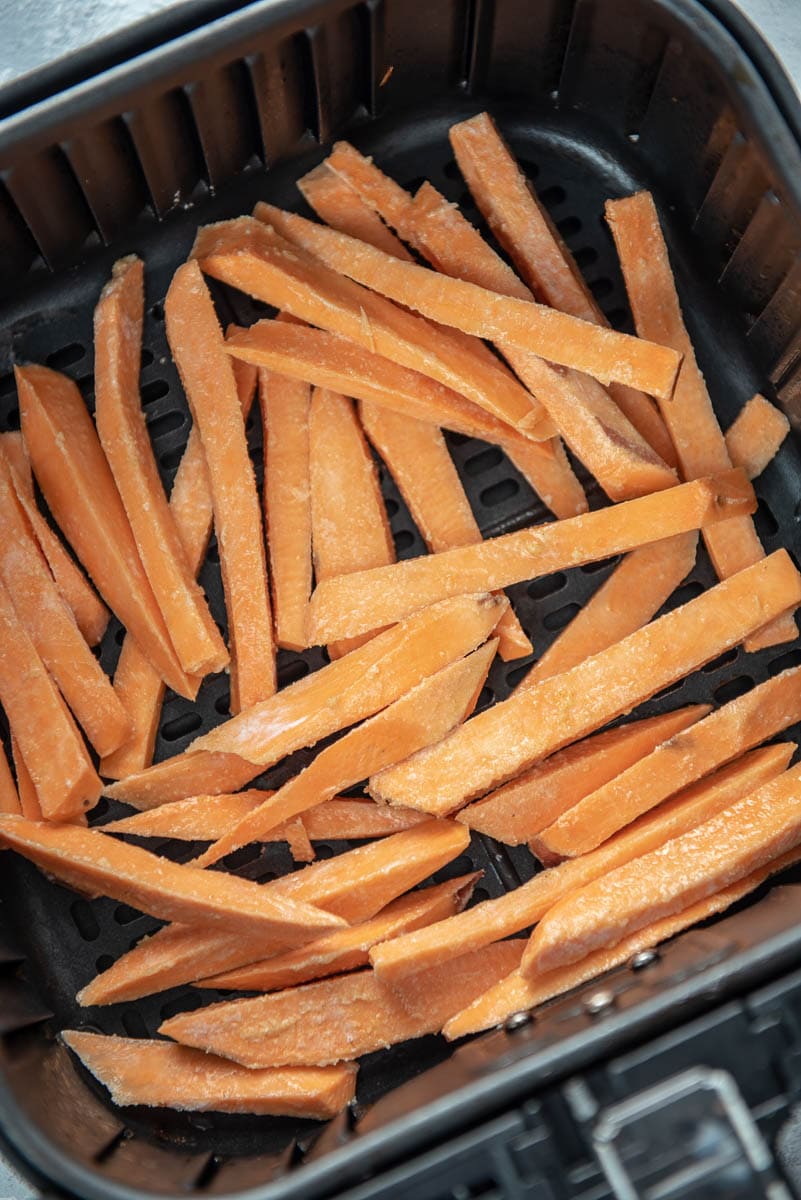 raw sweet potato fries in air fryer basket