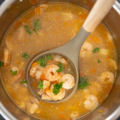 ladle full of shrimp and broth in instant pot