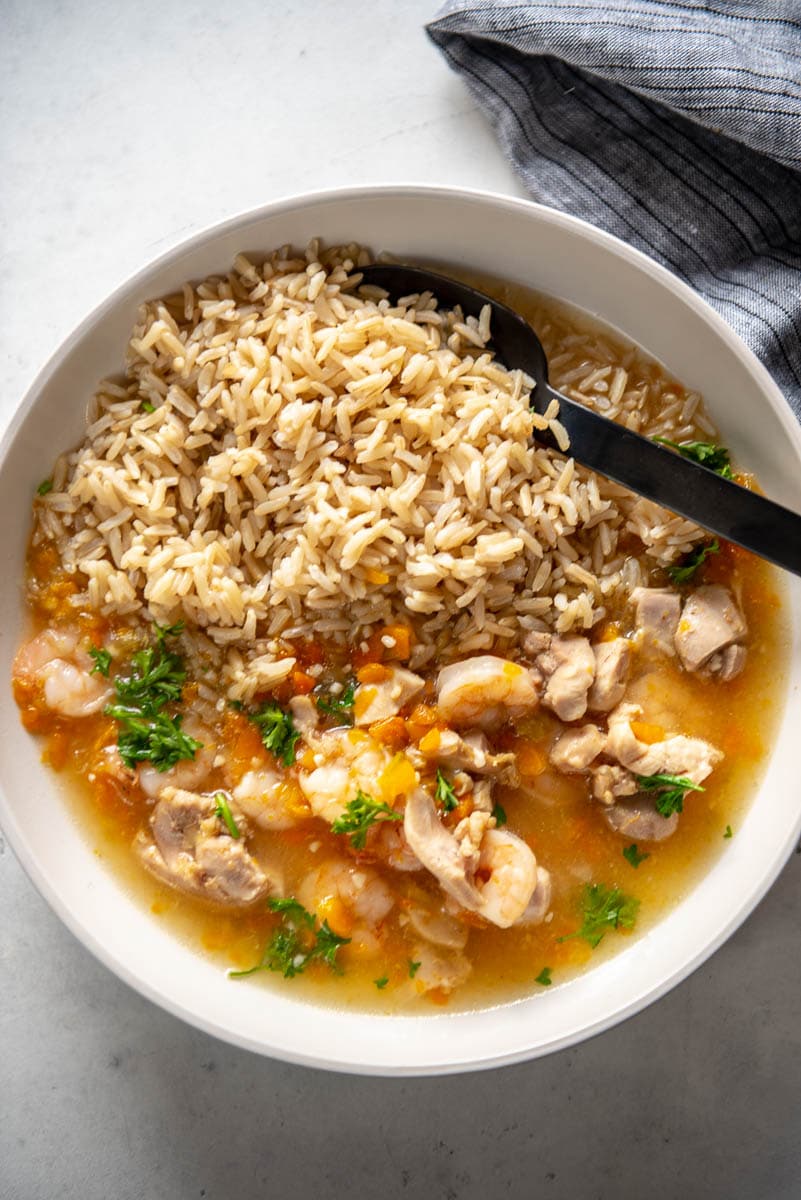 overhead view of white bowl filled with brown rice and chicken and shrimp gumbo