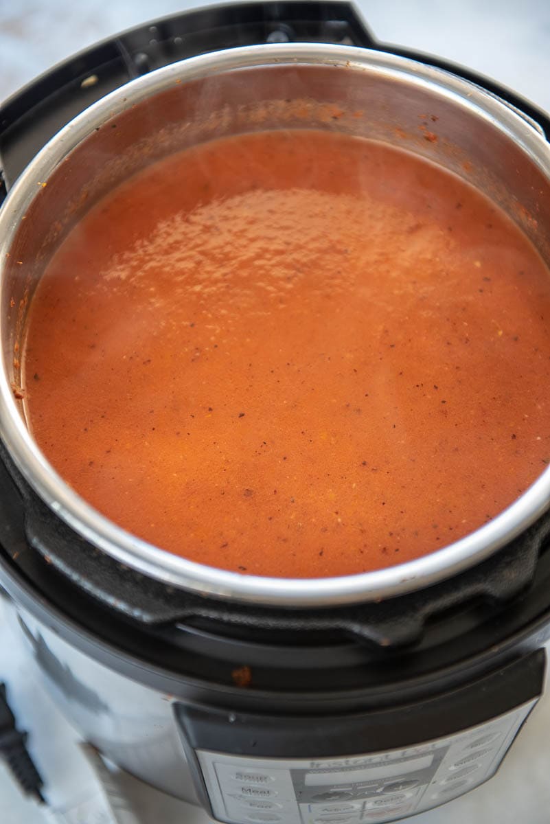 instant pot with creamy tomato soup with steam coming off top