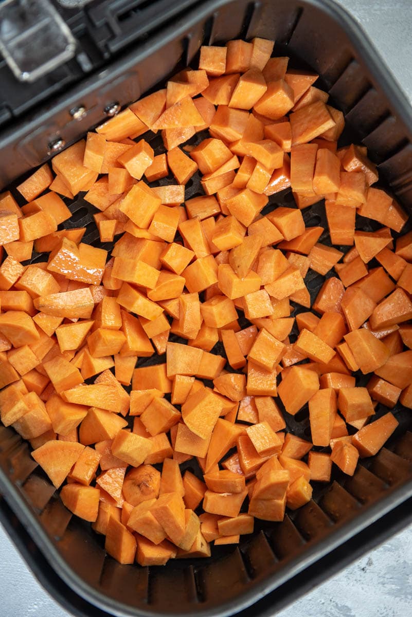 cubes of raw sweet potatoes in air fryer basket
