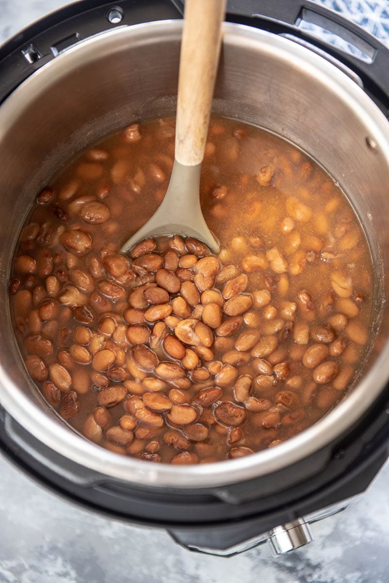 pinto beans in an Instant pot with wooden spoon