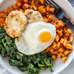 bowls with sweet potato cubes, greens, sausage patties and an egg