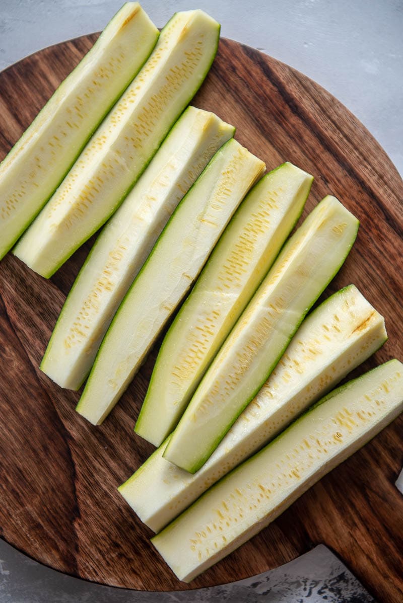 raw sliced zucchini on a cutting board