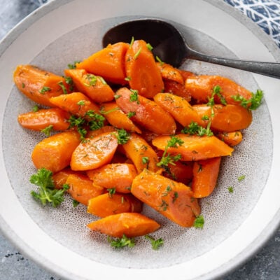 instant pot carrots in a white bowl with a spoon