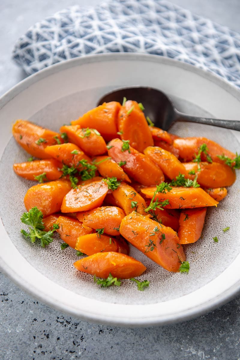carrots in a white bowl with a spoon