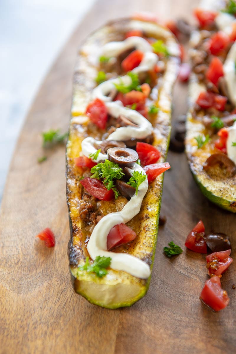 closeup of taco stuffed zucchini boat on a cutting board