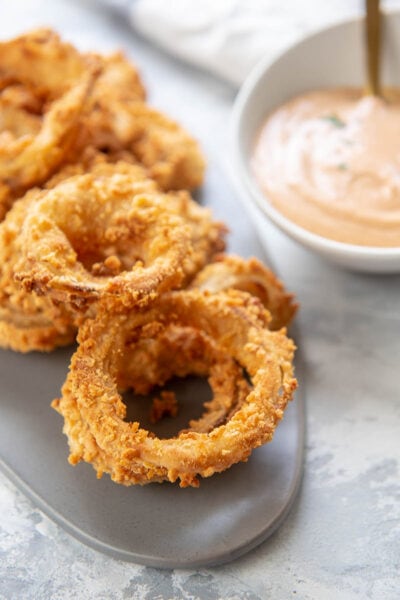 fried onion rings with a bowl of yum yum sauce
