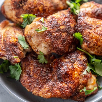 chicken thighs on a plate with garnish