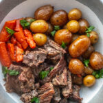 pot roast on a plate with potatoes and carroots