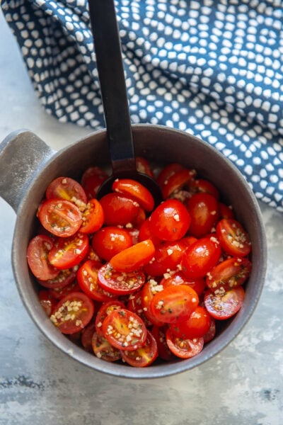 marinated tomatoes in a bowl with spoon